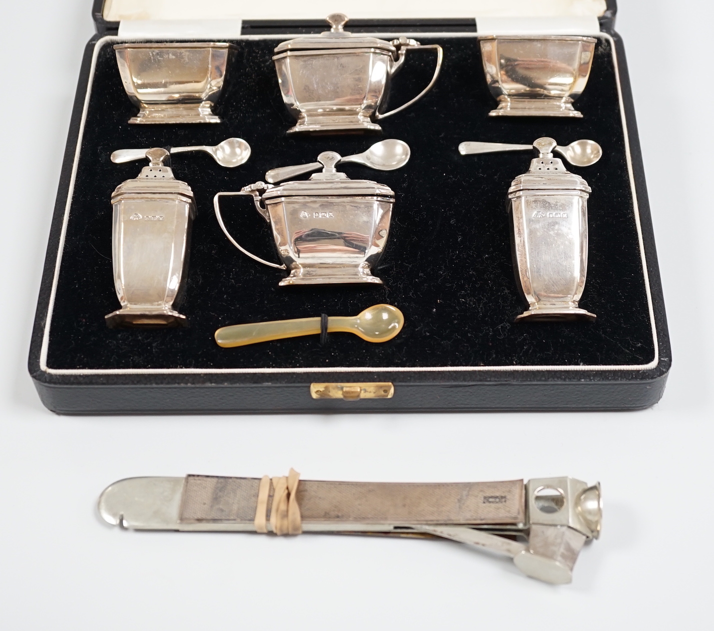 A cased Art Deco silver six piece condiment set, Adie Bros. Birmingham, 1936. with three (ex four) matching spoons, together with a silver mounted cigar cutter (a.f.).